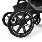 Close-up of a black stroller wheel on a white background