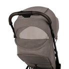 Nuna TRVL 360 lightweight travel stroller in Cedar brown, shown from the rear with the canopy extended to reveal a mesh ventilation window and a brown leatherette pushbar against a clean white background.