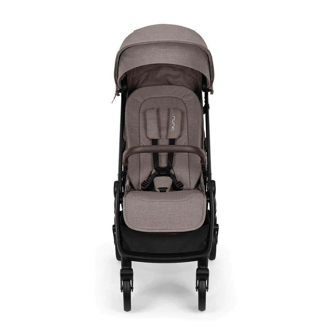 Nuna TRVL 360 lightweight travel stroller in Cedar brown, shown in a front view against a clean white background. The stroller features an extended sun canopy, a brown leatherette-accented pushbar and rotating armbar, a harness with a magnetic buckle, 360-degree swivel wheels, and an under-seat storage basket.