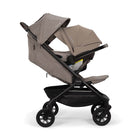 Nuna TRVL 360 lightweight travel stroller and PIPA urbn infant car seat system in Cedar brown, shown in a three-quarters front view against a clean white background.