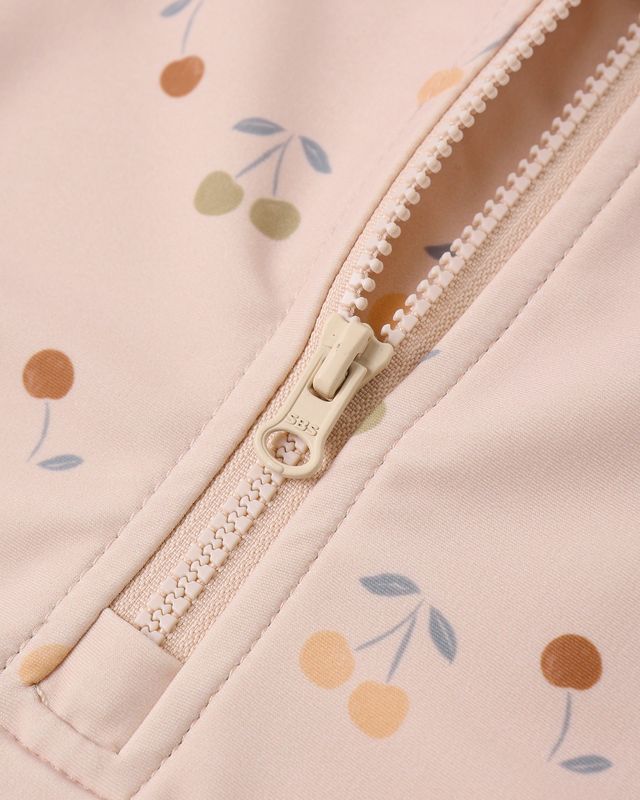 Close-up of a zipper on a pink fabric with floral patterns