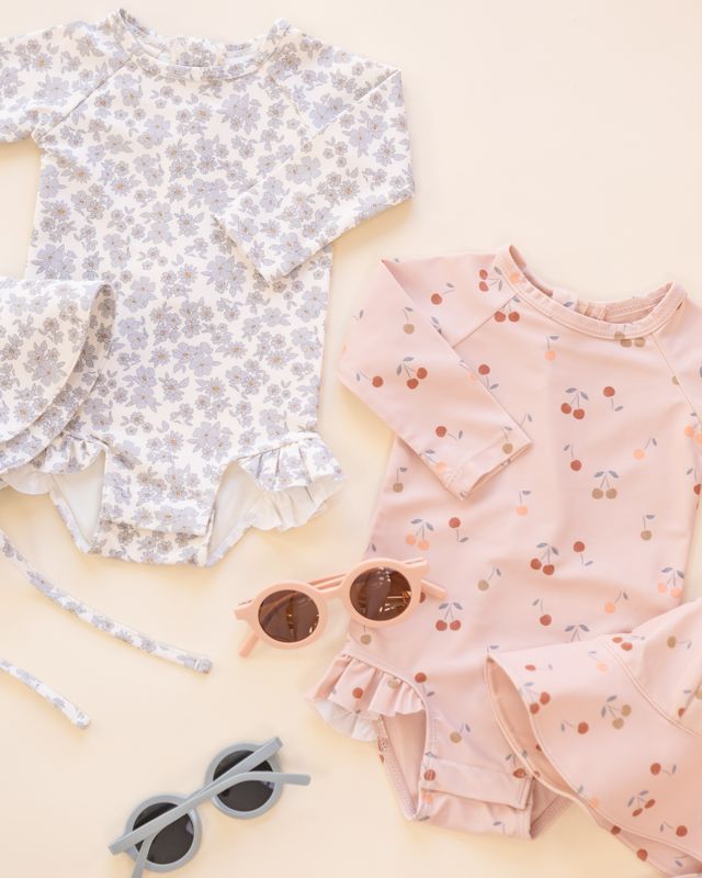 Two children's outfits with floral and polka dot patterns on a light background.