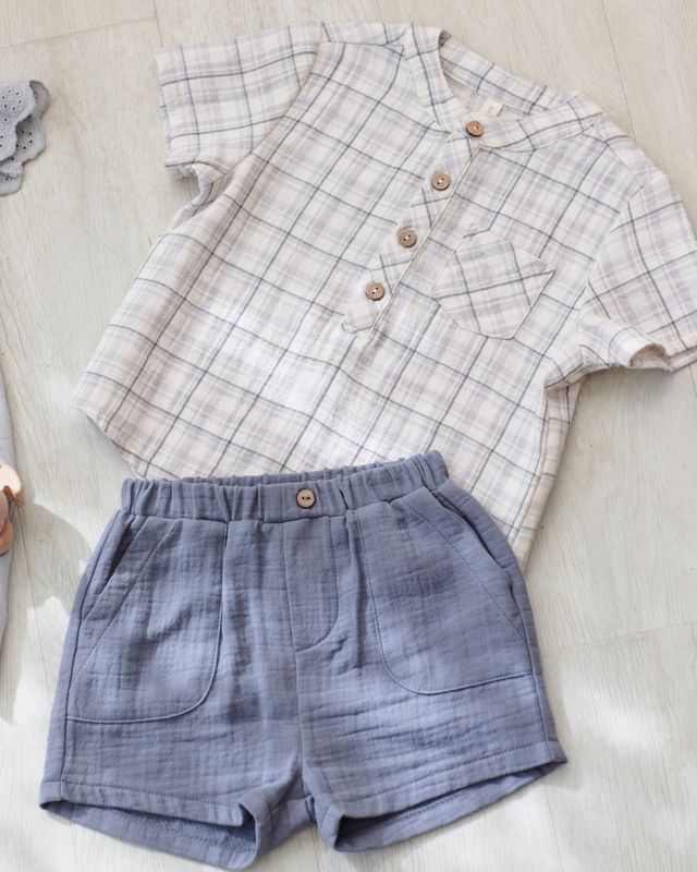 Plaid shirt and blue shorts on a light wooden surface