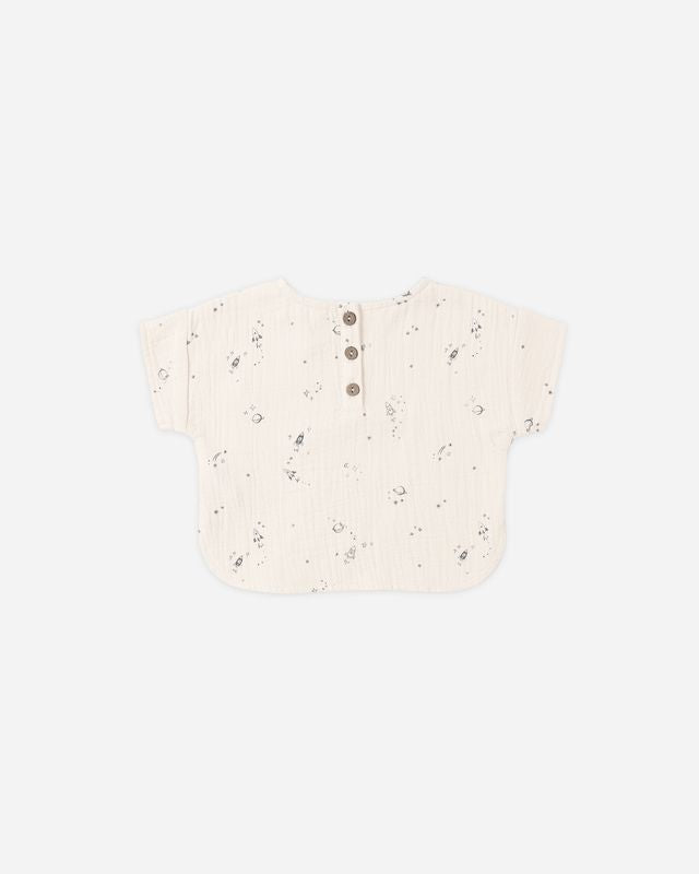 Speckled beige baby romper on a light gray background