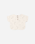 Speckled beige baby romper on a light gray background