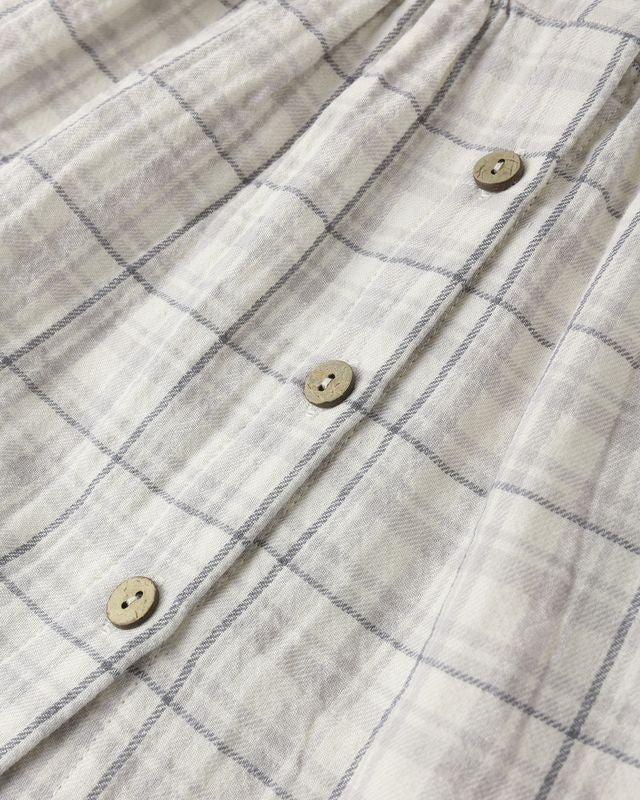 Close-up of a checkered shirt with buttons on a plain background