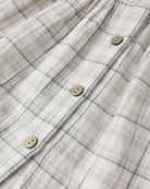 Close-up of a checkered shirt with buttons on a plain background