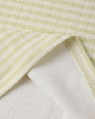 Close-up of light green and white striped fabric on a textured surface