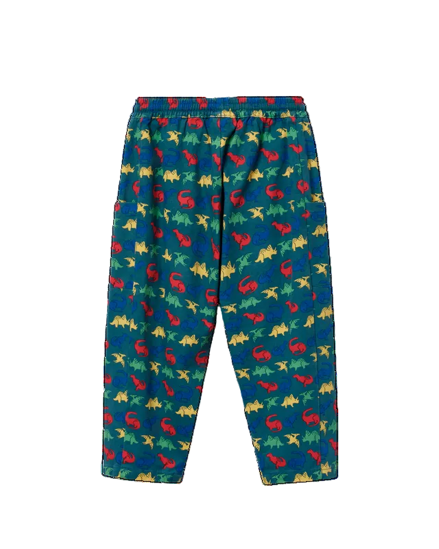Blue children's pants with an all-over dinosaur print in red, yellow, and green, featuring an elastic waistband and side pockets.