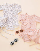 Children's floral dress and swimsuit with sunglasses on a light background