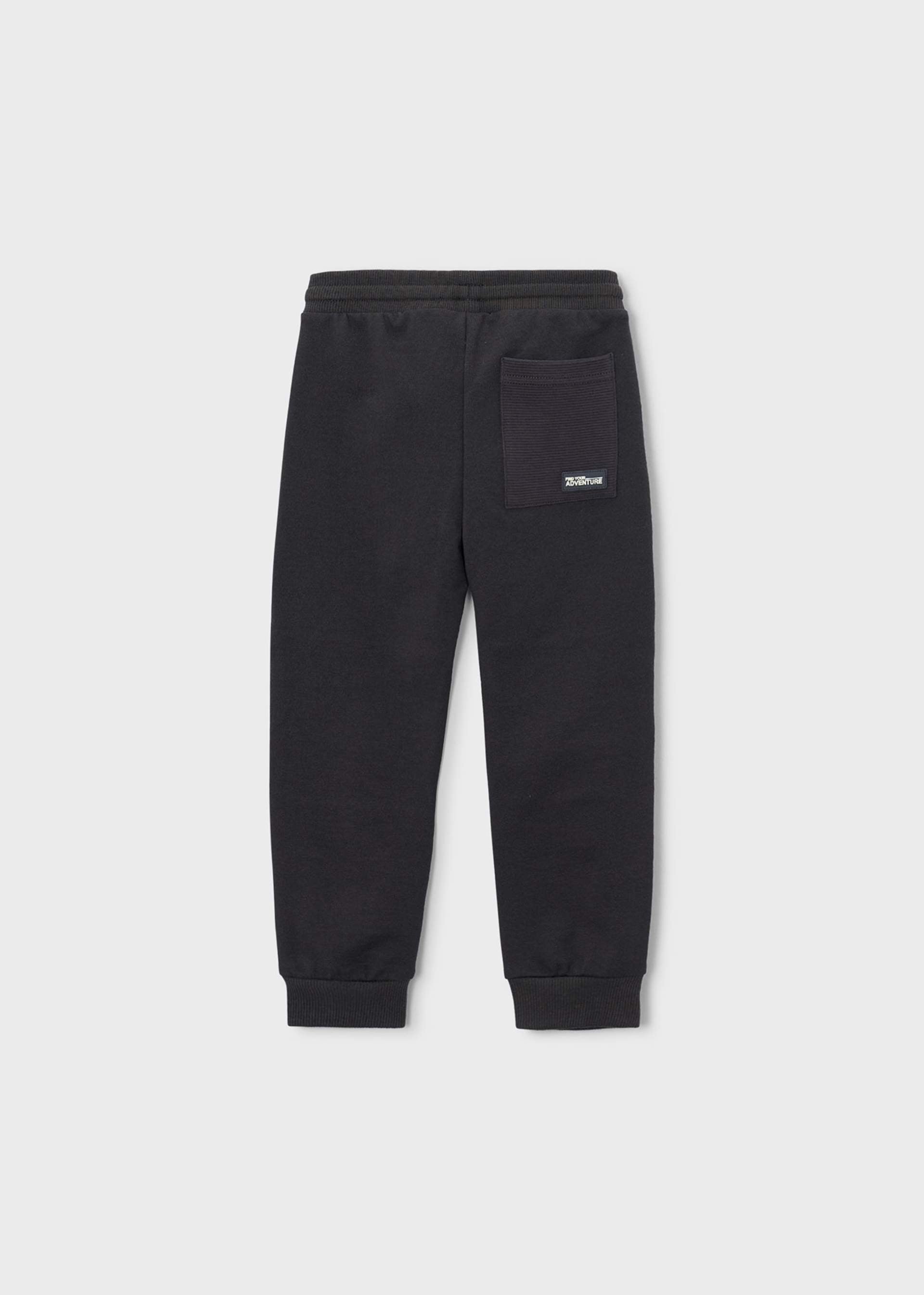 Black sweatpants with a side pocket and a small white logo patch, shown flat against a light gray background.