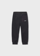 Black sweatpants with a side pocket and a small white logo patch, shown flat against a light gray background.