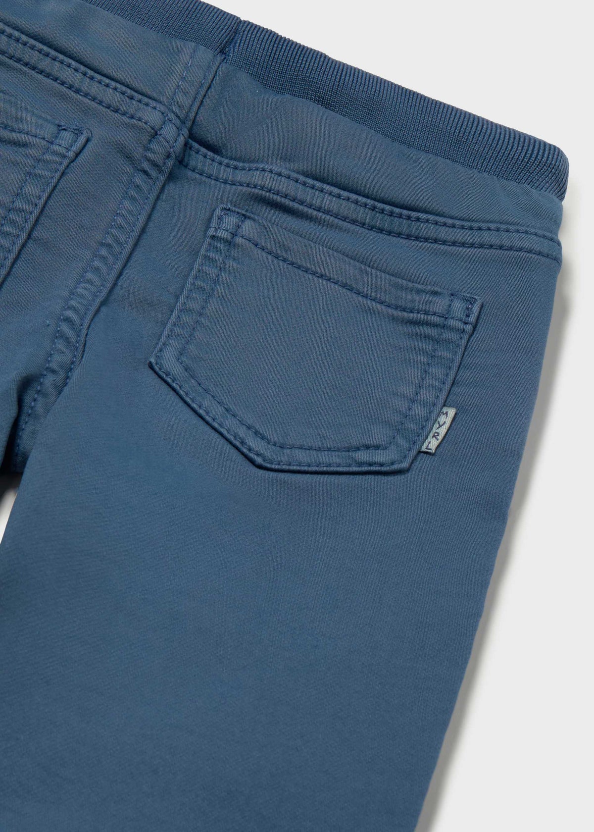 Close-up of blue pants with a pocket on a light gray background