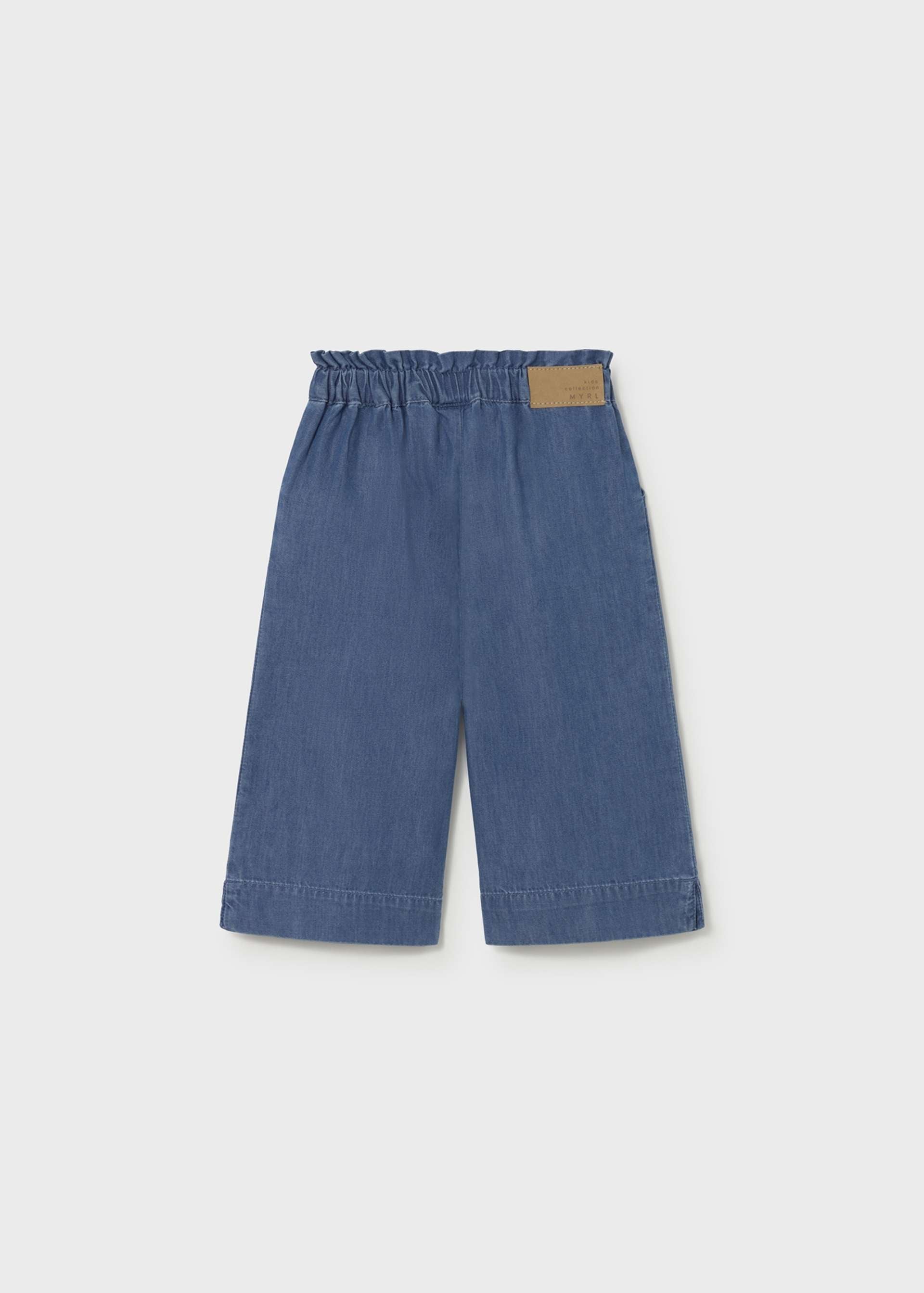 Blue denim pants with a brown patch on a light gray background