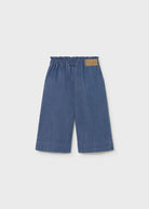 Blue denim pants with a brown patch on a light gray background