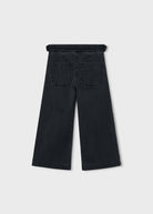 Black wide-leg cropped jeans shown from the back, featuring a drawstring waistband and two back patch pockets, on a light gray background.