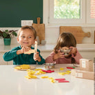 Two children playing with play dough in a kitchen setting