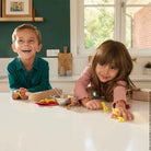Two children playing with toys on a kitchen counter.