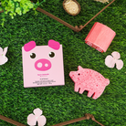 Pink pig-shaped product with packaging on a grassy background