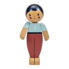Wooden toy figure with blue top and red pants on a white background