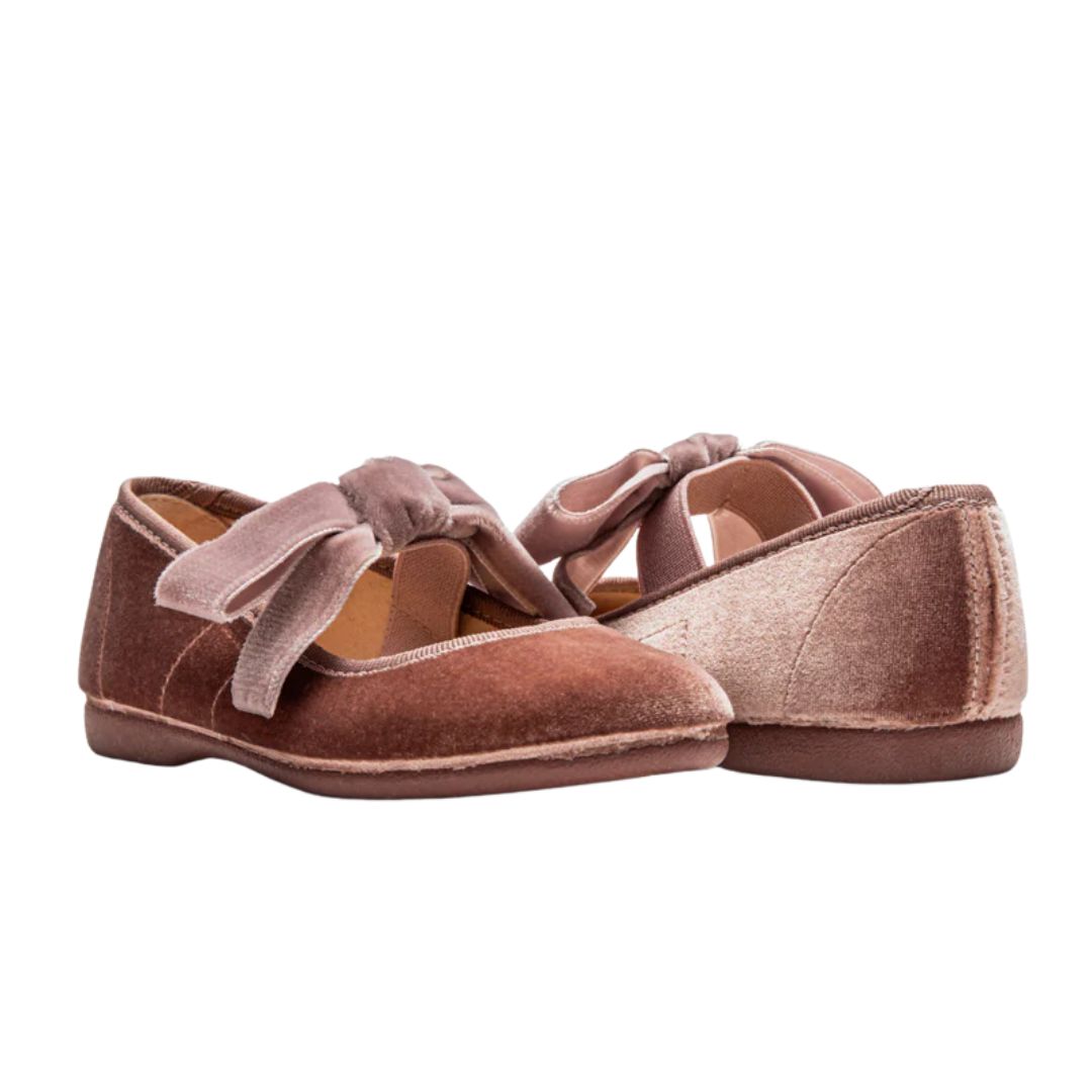 Pair of brown suede shoes with bow details on a white background