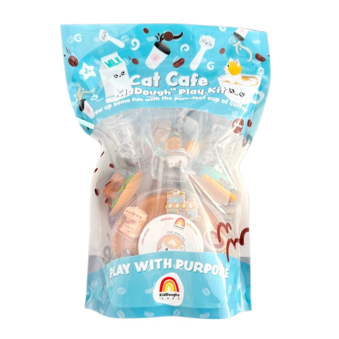 A clear stand-up pouch package containing a KidDough play kit labeled 'Cat Cafe' on a plain white background. The package is light blue with cartoon cat graphics and visible toy pieces inside, including a small cup, bowls, and other miniature accessories.