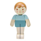 A hand-painted wooden toy figure with a round head, light brown hair, a cream face, pink cheeks, and a light blue shirt with cream-colored arms and legs, shown against a plain white background.
