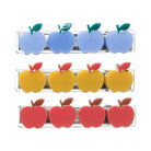 Six clear plastic hair clips shaped like apples, arranged in three rows of two. The top row clips feature light blue apples with green leaves, the middle row clips feature yellow apples with red leaves, and the bottom row clips feature red apples with brown leaves.