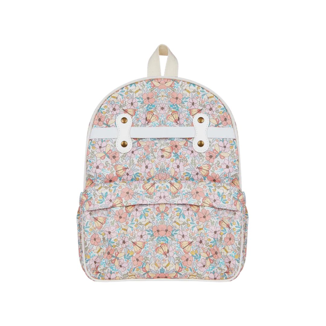 A small backpack with a pastel floral and butterfly pattern on a light pink background, featuring a white horizontal strap across the top front with two gold-tone grommets and a cream-colored top handle, shown against a plain white background.