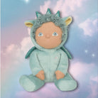 Stuffed toy with a green costume on a pastel background