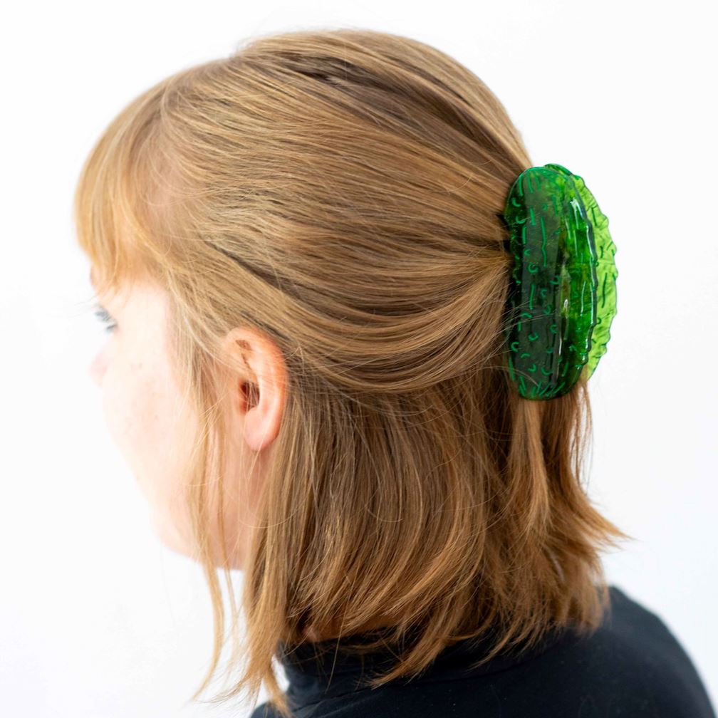 Person with green hair clip in their hair on a white background