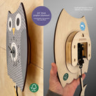Wooden owl clock with a hand holding it, showing the back design.