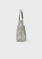 Handbag with leaf pattern on a light gray background