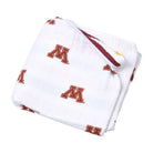 Folded white blanket with red and yellow 'M' logos on a white background