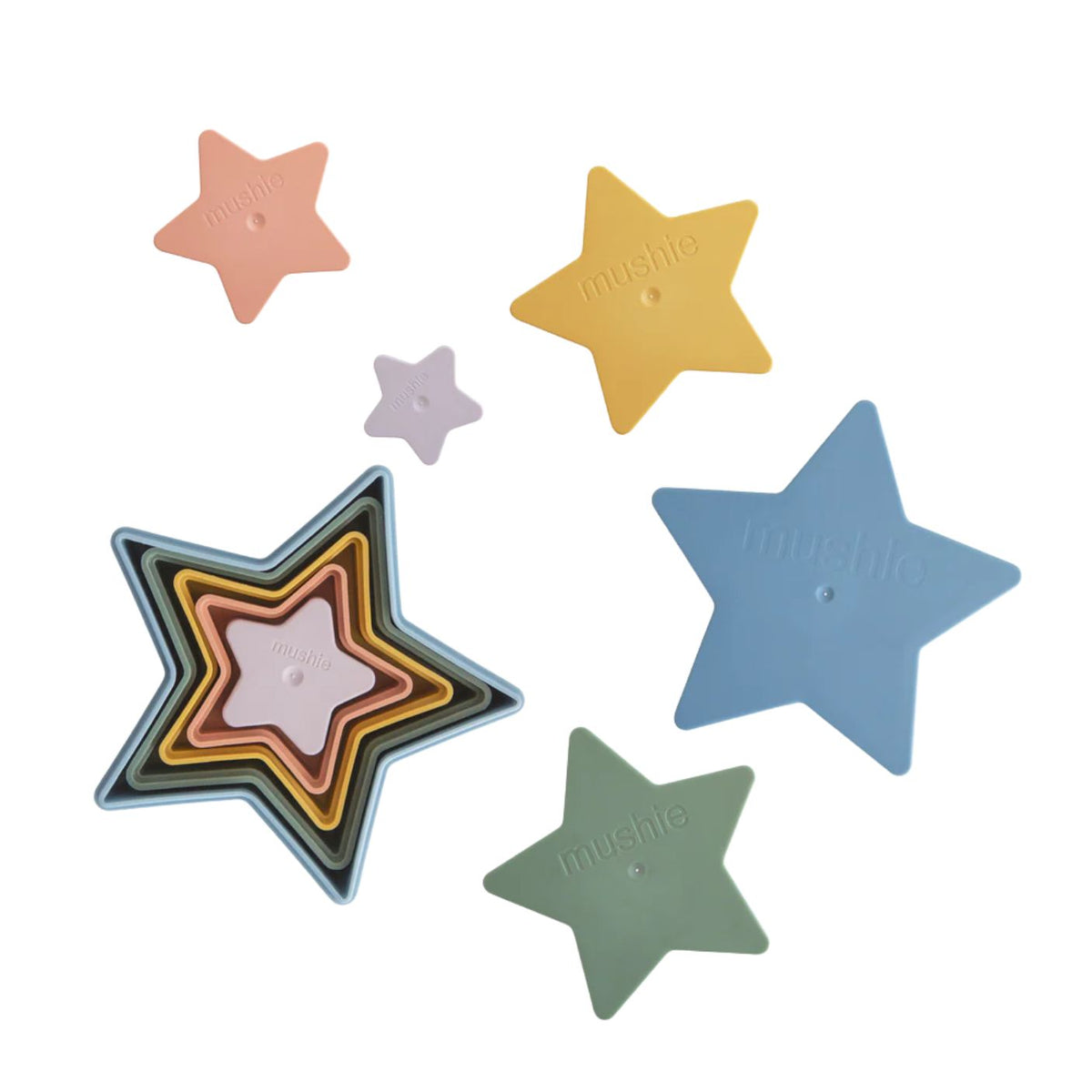 Five star-shaped nesting plastic trays in pastel shades of peach, yellow, lavender, blue, and sage green, arranged on a plain white background. The brand name 'mushie' is embossed in the center of each star.