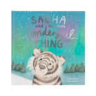 Children's book cover titled 'SACHA and the most wonderful THING' featuring a striped tiger cub in a snowy winter landscape under a colorful aurora sky.