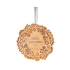 Wooden ornament with floral design and engraved text on a white background