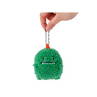 Green plush keychain with a face held by a hand on a white background