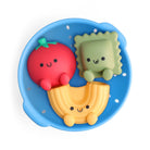 Colorful silicone pasta toys with smiling faces in a blue tray on a white background