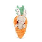 Plush toy rabbit inside a carrot with green leaves on a white background