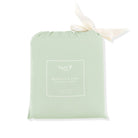 A light sage green drawstring pouch with a white printed label reading 'Kyte Baby Bamboo Crib Sheet' and a cream satin ribbon tied in a bow at the top, shown on a white background.