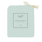 Kyte Baby bamboo crib sheet packaging on a light green background