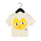 Beige t-shirt with a yellow cat face design on a hanger against a white background