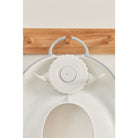 White kitchen tool with a wooden cutting board in the background