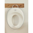 Children's potty seat with a wooden hook on a beige background