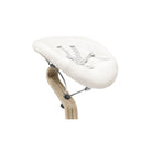 White bicycle seat on a wooden stand against a white background