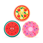 Three round, paper-like decorative plates or coasters with cartoon food illustrations: a pizza with pepperoni and mushrooms, a watermelon slice with seeds, and a pink donut with sprinkles, shown on a light gray background.