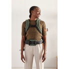 Person wearing a green backpack against a plain background