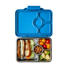 Blue lunch box with compartments containing a hot dog, vegetables, and a small dish on a white background
