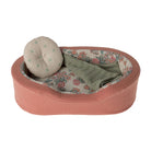 Small pink fabric box with floral interior, containing a polka dot item and green fabric.
